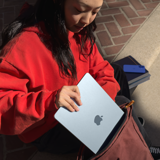 Étudiante rangeant un MacBook Air dans son sac à dos